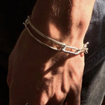 Knife edged chain bracelet with a toggle clasp on male models hand 