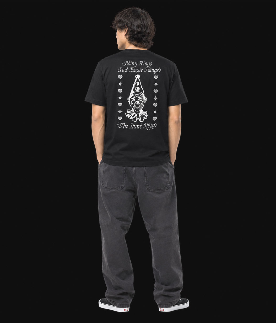 Person wearing a black t-shirt with white graphic design on the back, standing against a plain background.
