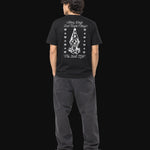 Person wearing a black t-shirt with white graphic design on the back, standing against a plain background.