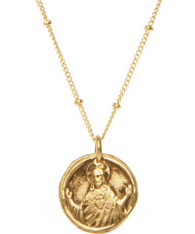 Gold necklace with a religious pendant on a white background