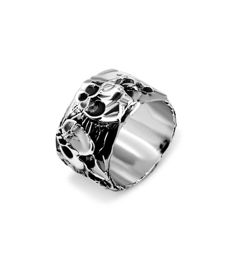 Silver ring with intricate design on a white background