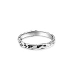 Silver ring with a subtle design on a white background
