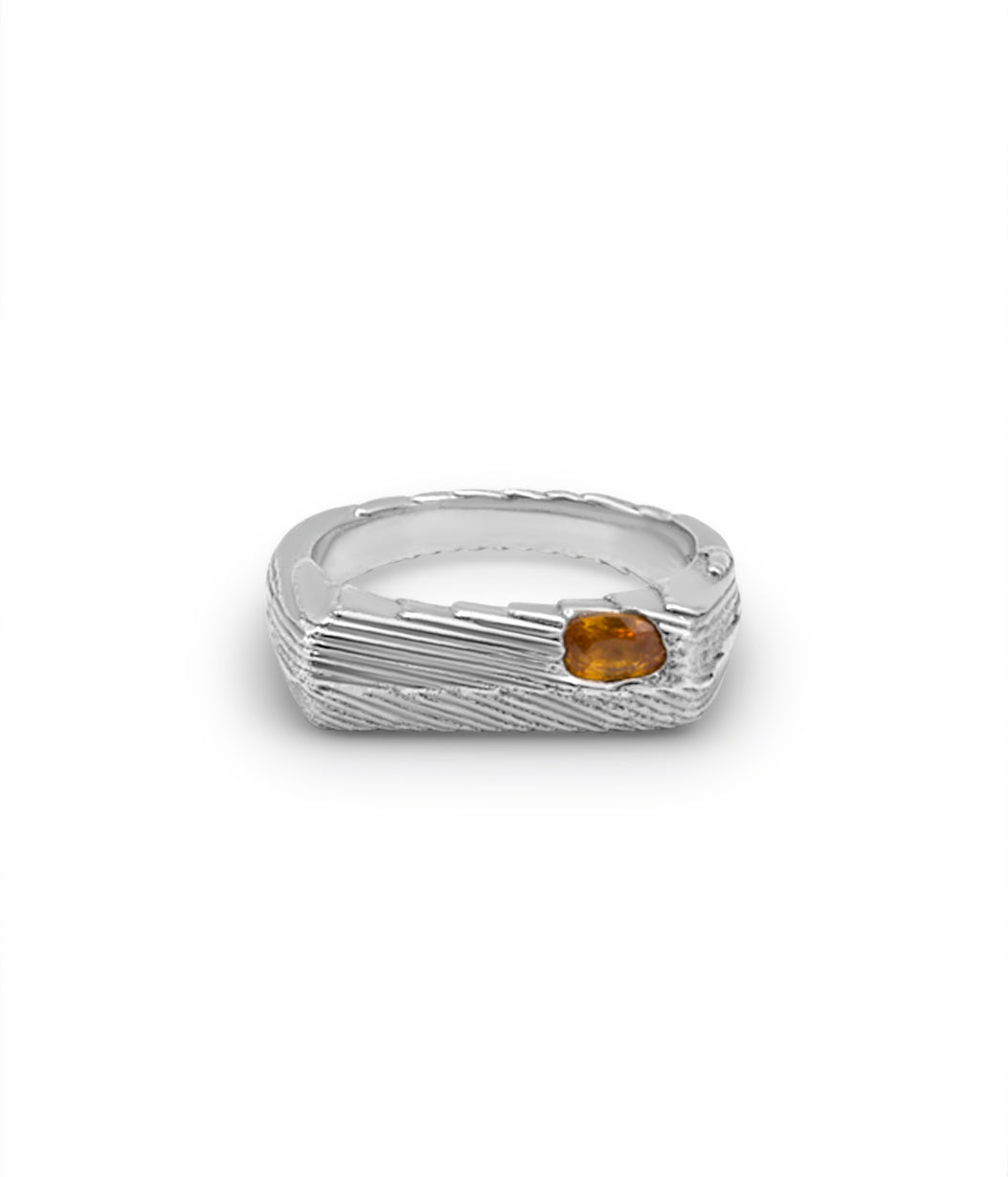 Silver ring with a small orange gemstone on a white background