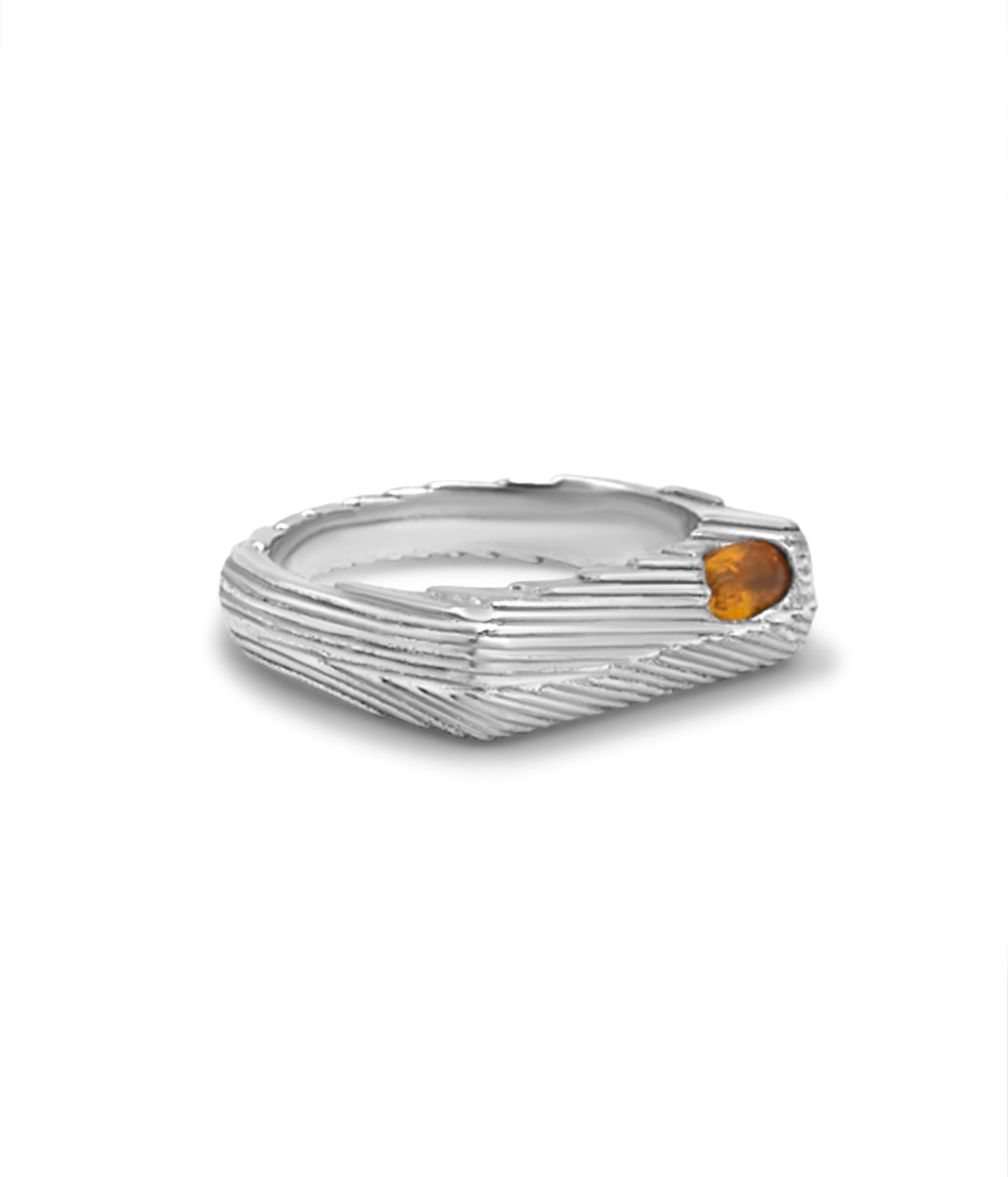 Silver ring with a small orange gemstone on a white background