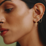 Close-up of a woman wearing gold earrings with a blurred background