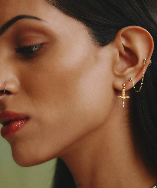 Close-up of a woman wearing gold earrings with a blurred background