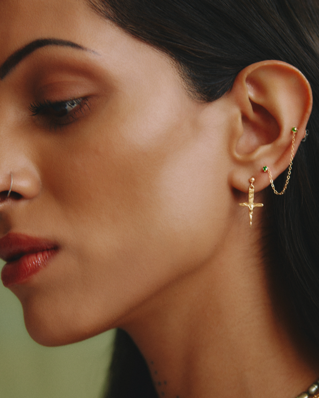 Close-up of a woman wearing gold earrings with a blurred background