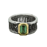 Silver ring with a green gemstone on a white background