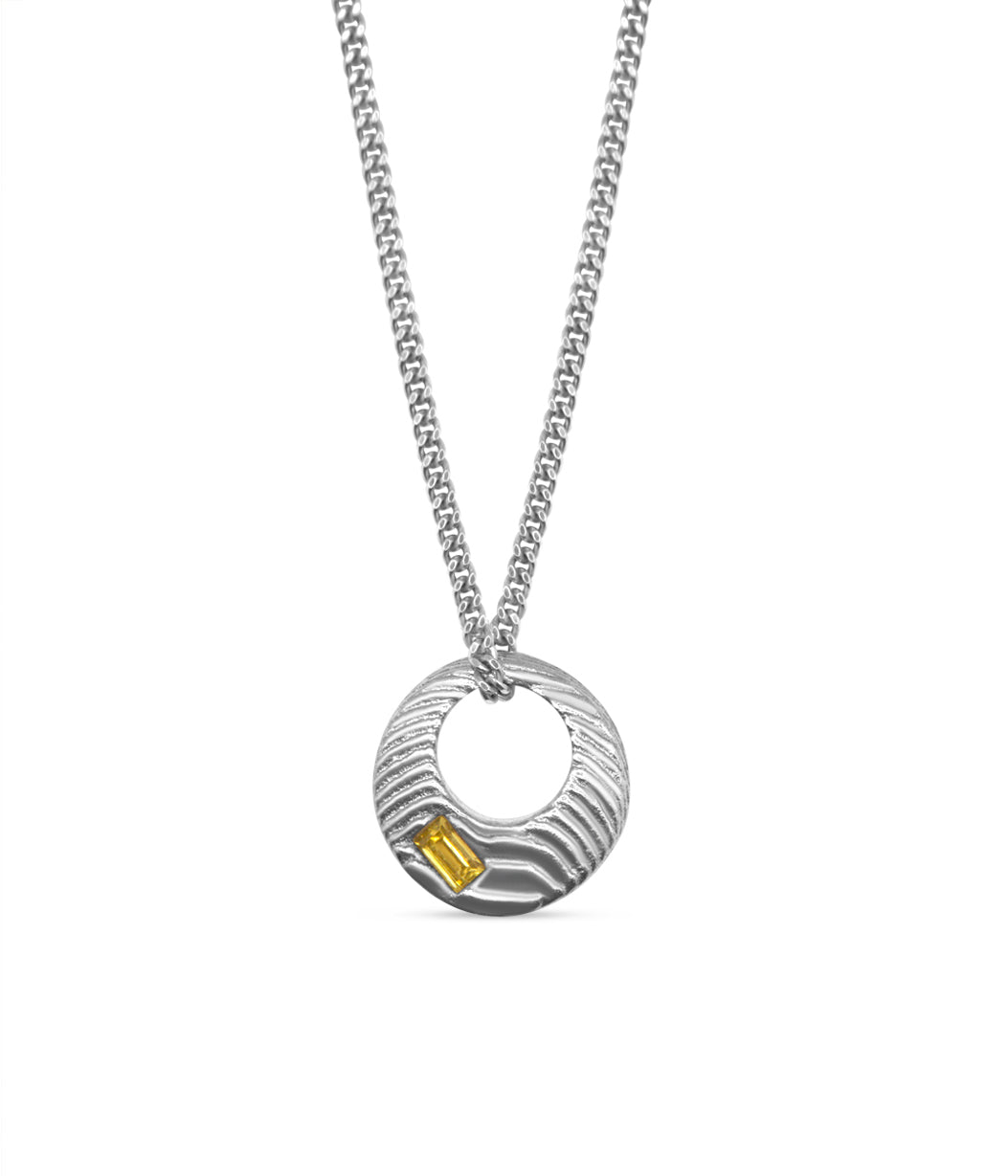 Silver necklace with a circular pendant on a white background