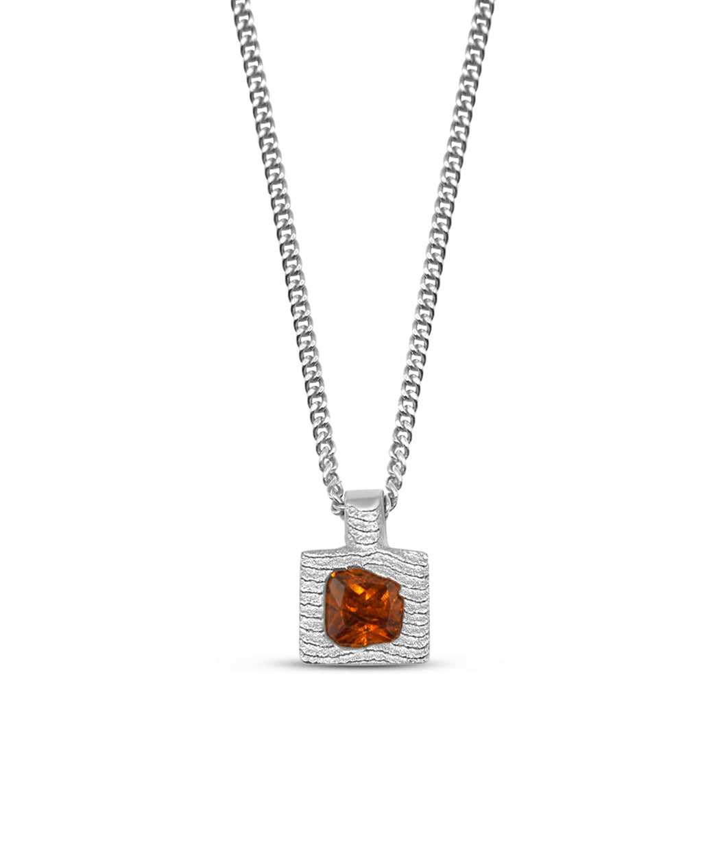 Silver necklace with a square pendant featuring an orange gemstone on a white background