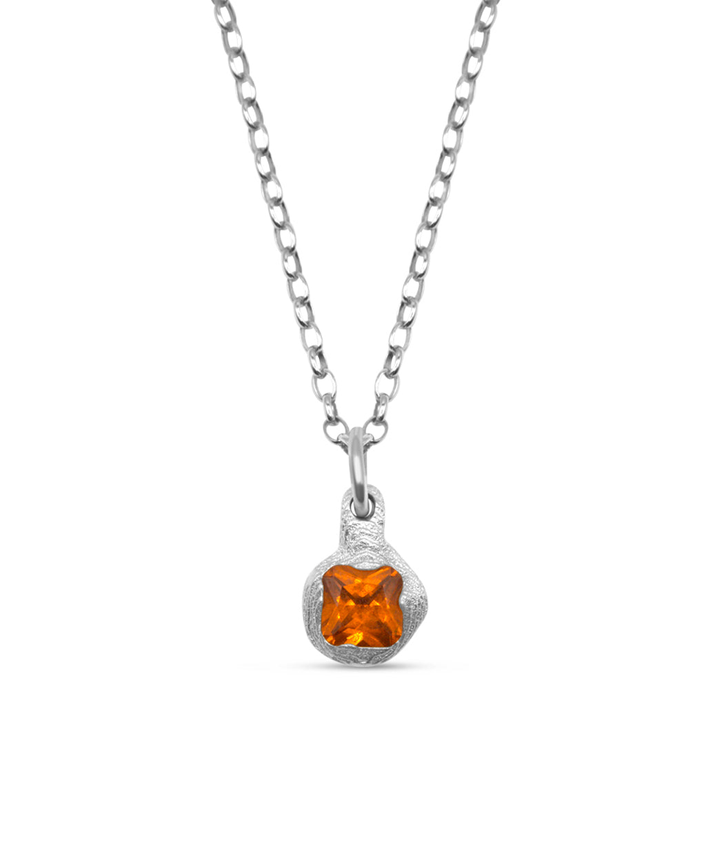 Silver necklace with a pendant featuring an orange gemstone on a white background