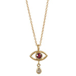 Gold necklace with eye-shaped pendant featuring a red gemstone and a small diamond on a white background