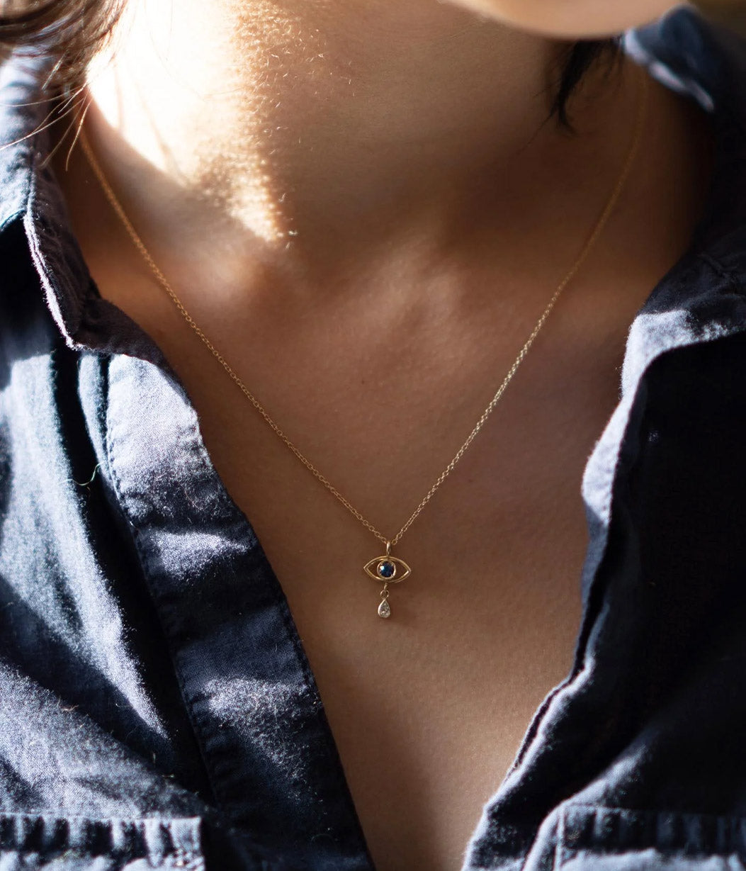 Necklace with a pendant worn by a person against a dark shirt.