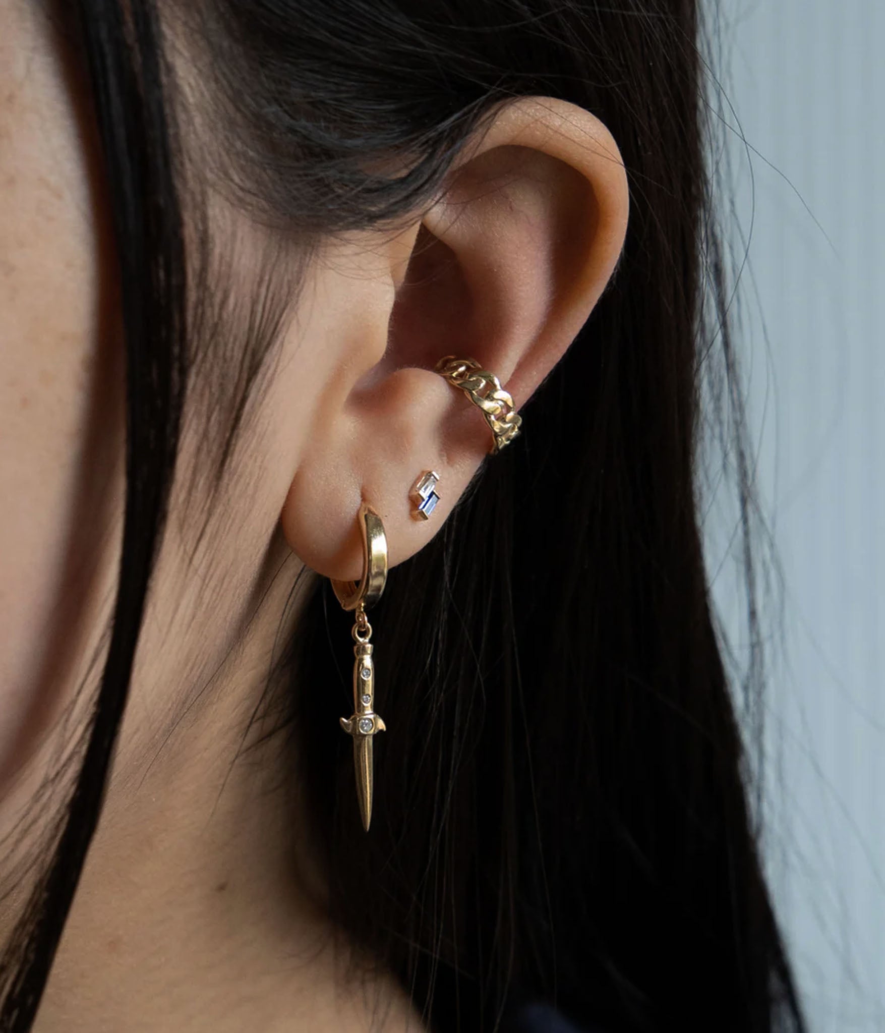 Female model wearing 3 earrings including counterbalance stud earring in 14k yellow gold 