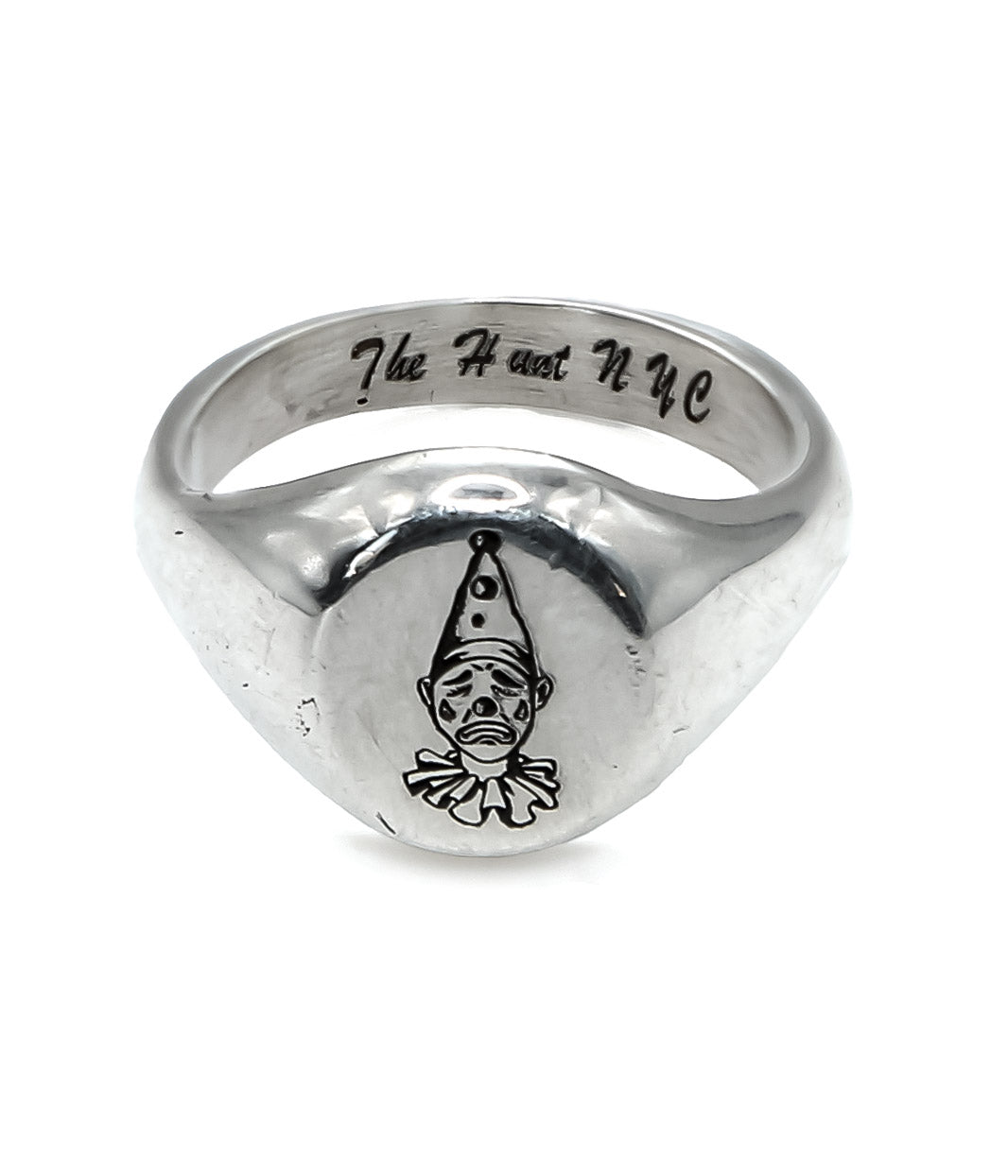 Silver ring with a clown design and 'The Heart NYC' engraving on a white background