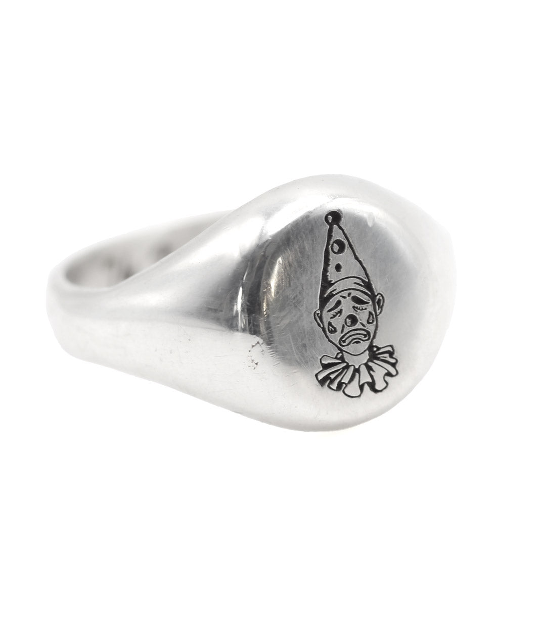 Silver ring with a clown face design on a white background