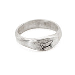 Silver ring with a dog design on a white background