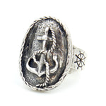 Silver ring with anchor and cross design on a white background