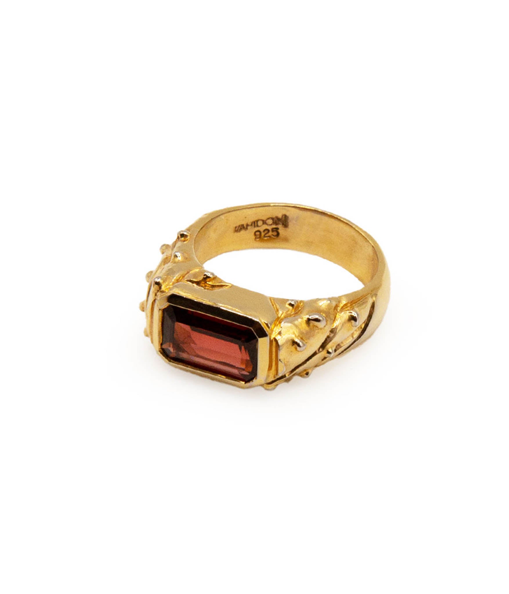 Gold ring with a red gemstone on a white background
