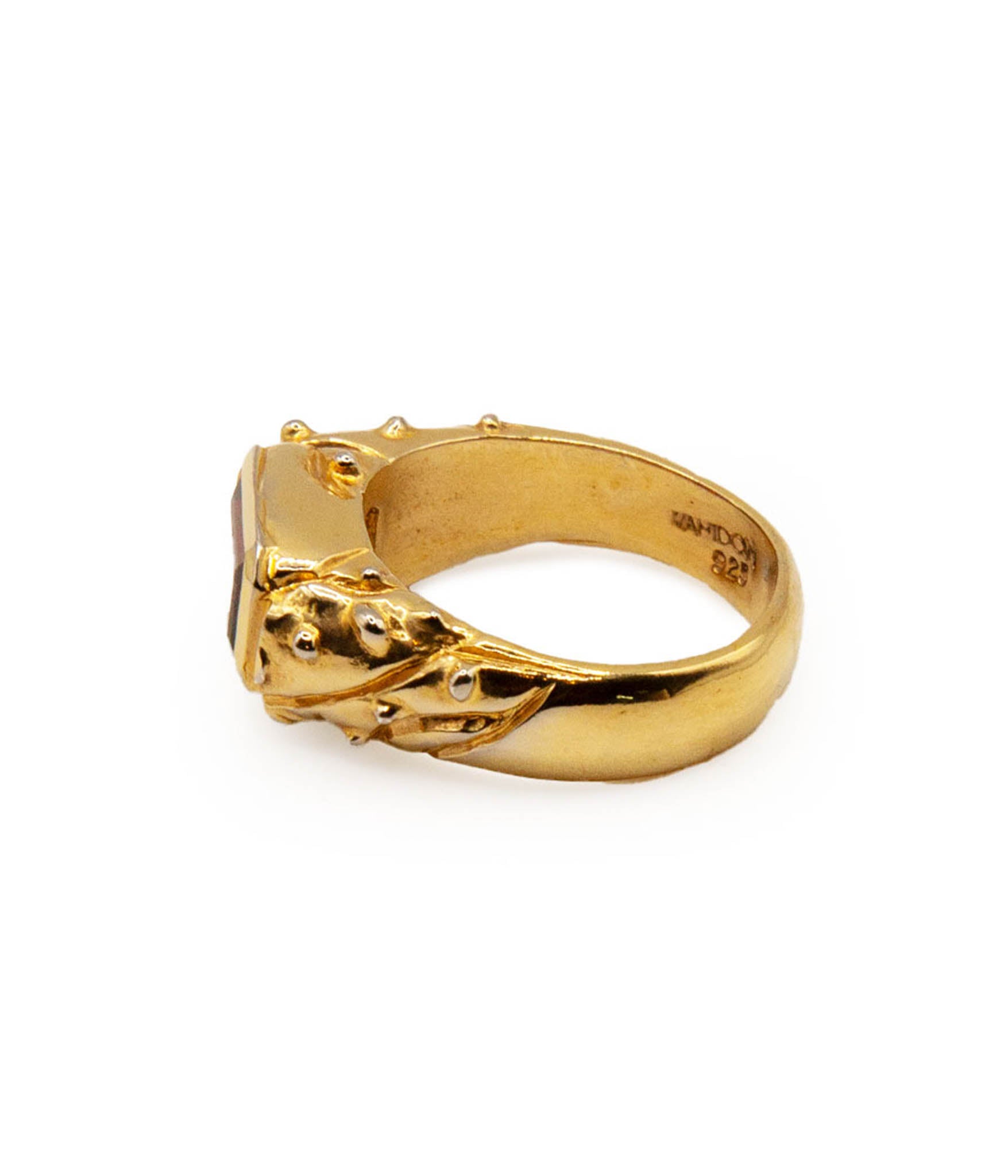 Gold ring with a textured band on a white background