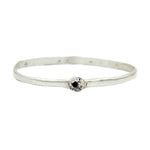 Silver bracelet with a black gemstone on a white background
