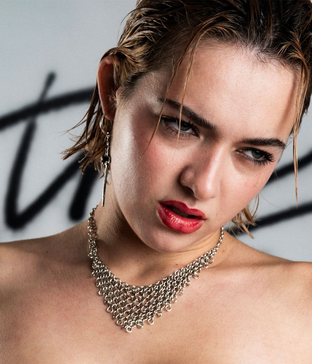 Woman wearing a silver necklace with a blurred background