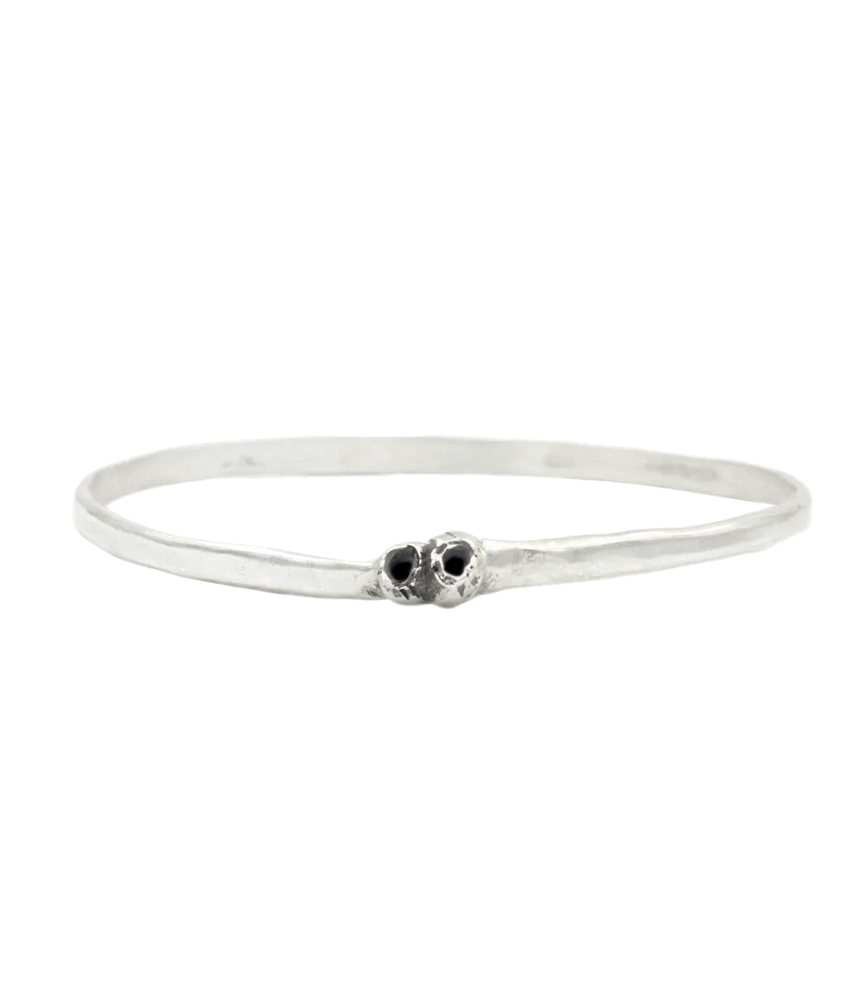 Silver bracelet with two small black stones on a white background