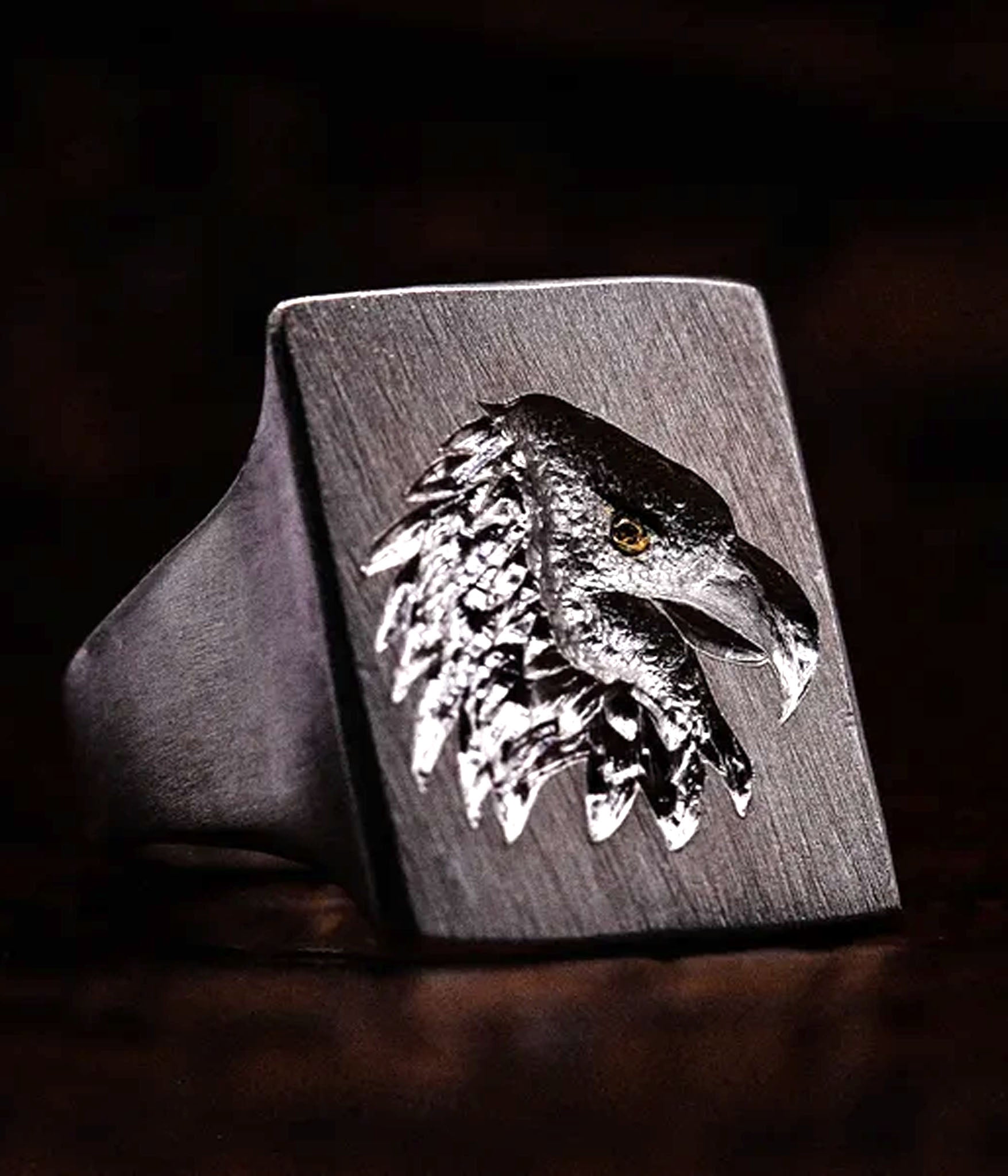 Silver eagle head ring on a dark background