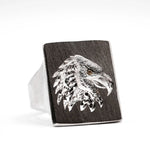 Silver eagle head design on a wooden ring with a white background