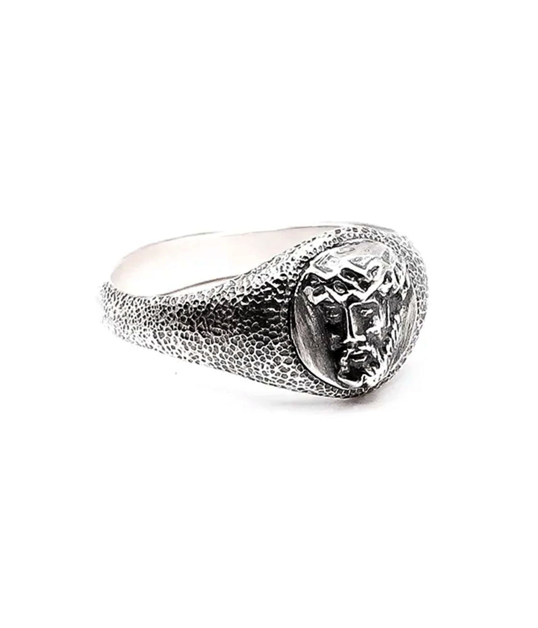 Silver ring with a textured band and central gemstone on a white background