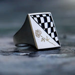 Checkered ring with a rose design on a dark surface
