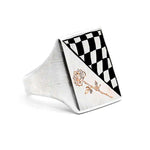 Silver ring with black and white checkered design and rose engraving on a white background
