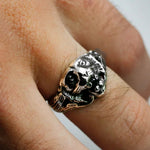 Silver skull ring on a finger with a blurred background