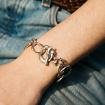 Silver chain bracelet on a wrist with denim background