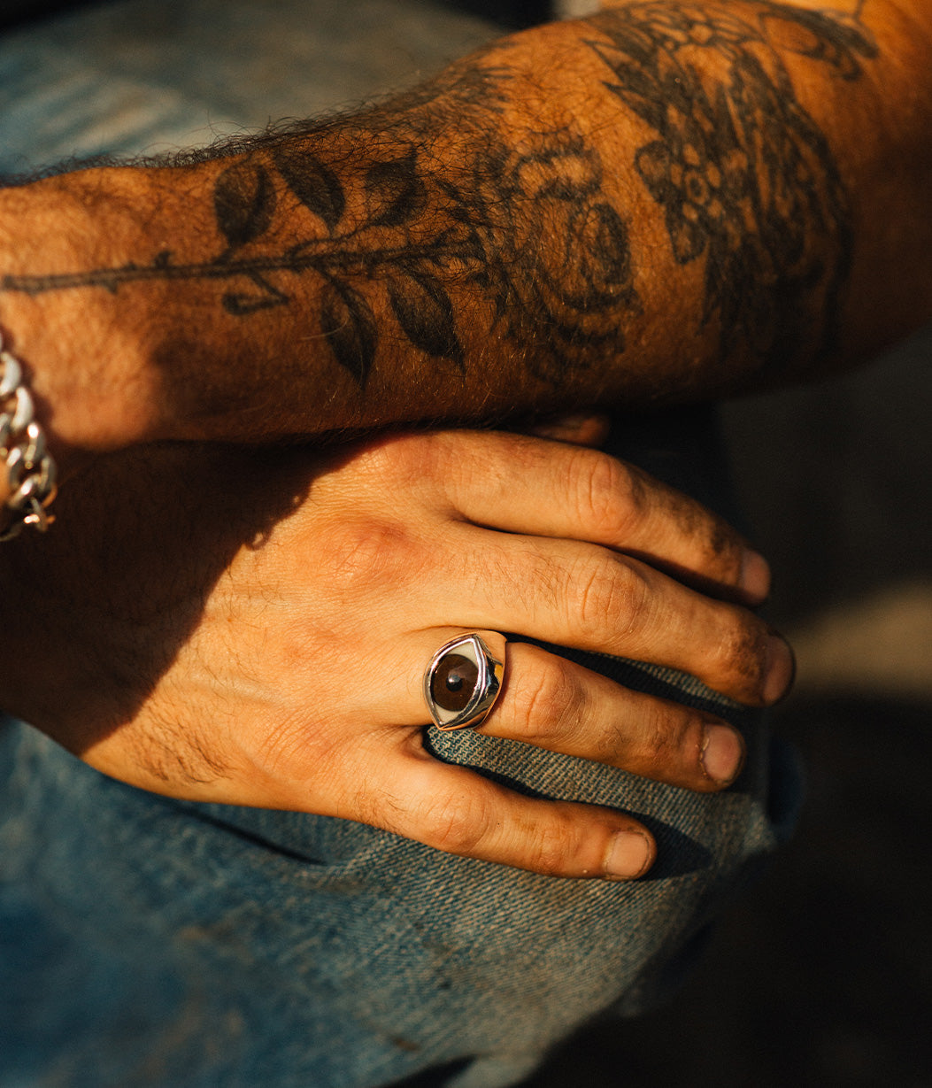 Hand with a ring and tattoos on a blurred background