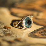 Ring with a blue stone on a textured surface