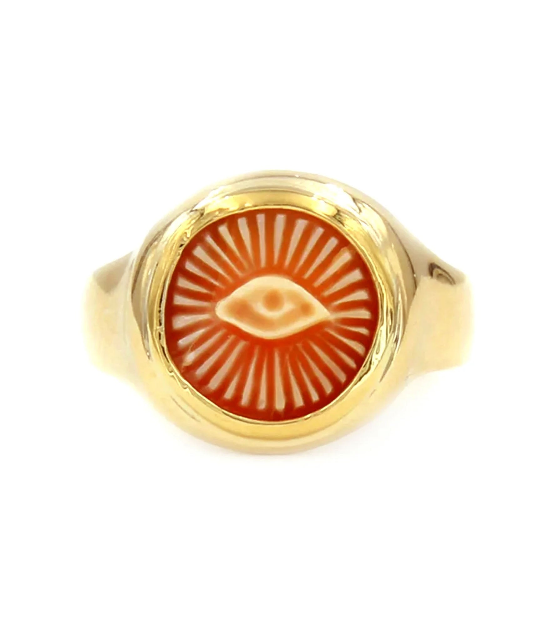 Gold ring with a red stone featuring an eye design on a white background