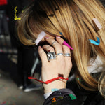 Person with colorful hair clips and rings on a blurred background
