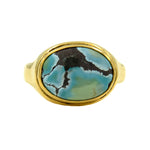 Gold ring with a turquoise stone on a white background