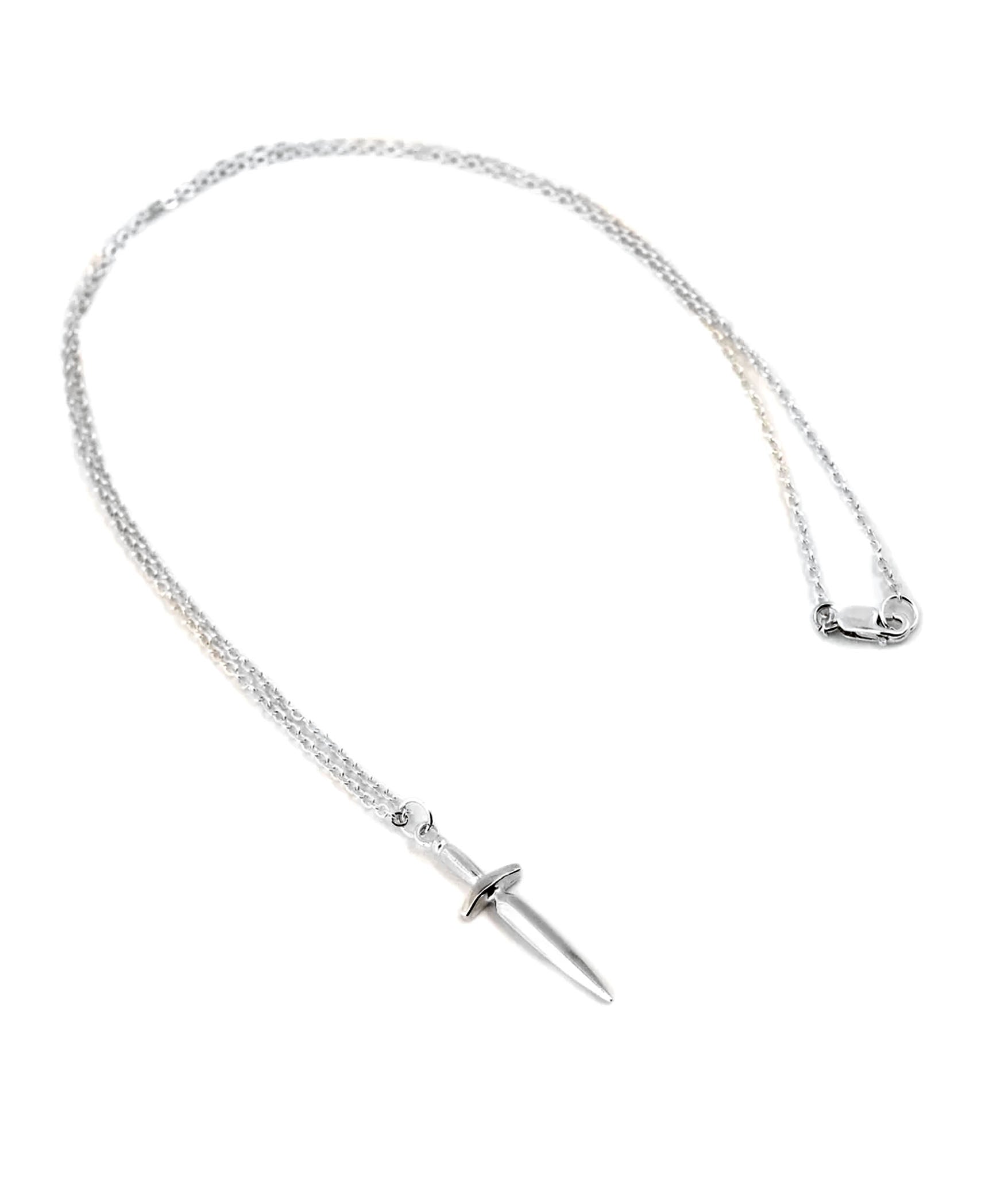 Flat lay of sterling silver dagger pendant necklace by The Hunt – sharp blade charm on polished chain with lobster clasp closure