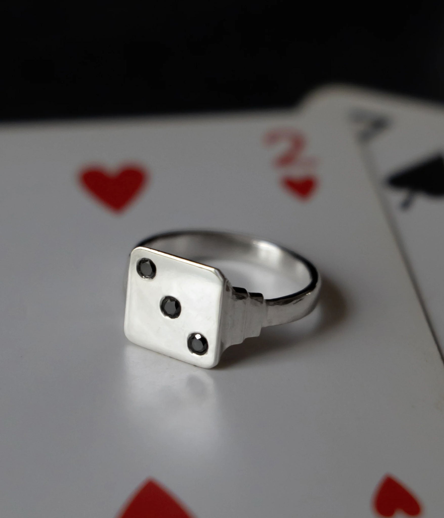 sterling silver vintage inspired dice signet with 3 diamonds shot on top of a deck of cards