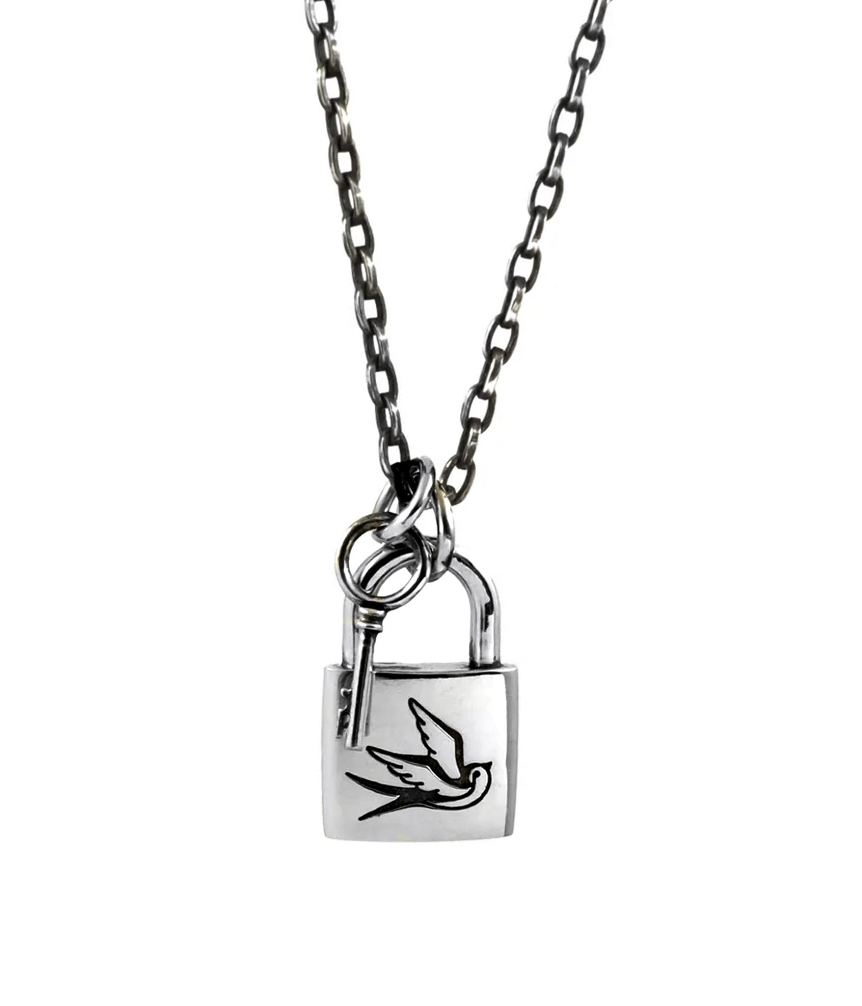 Close-up of silver padlock necklace with engraved swallow and key on dark chain, hanging freely