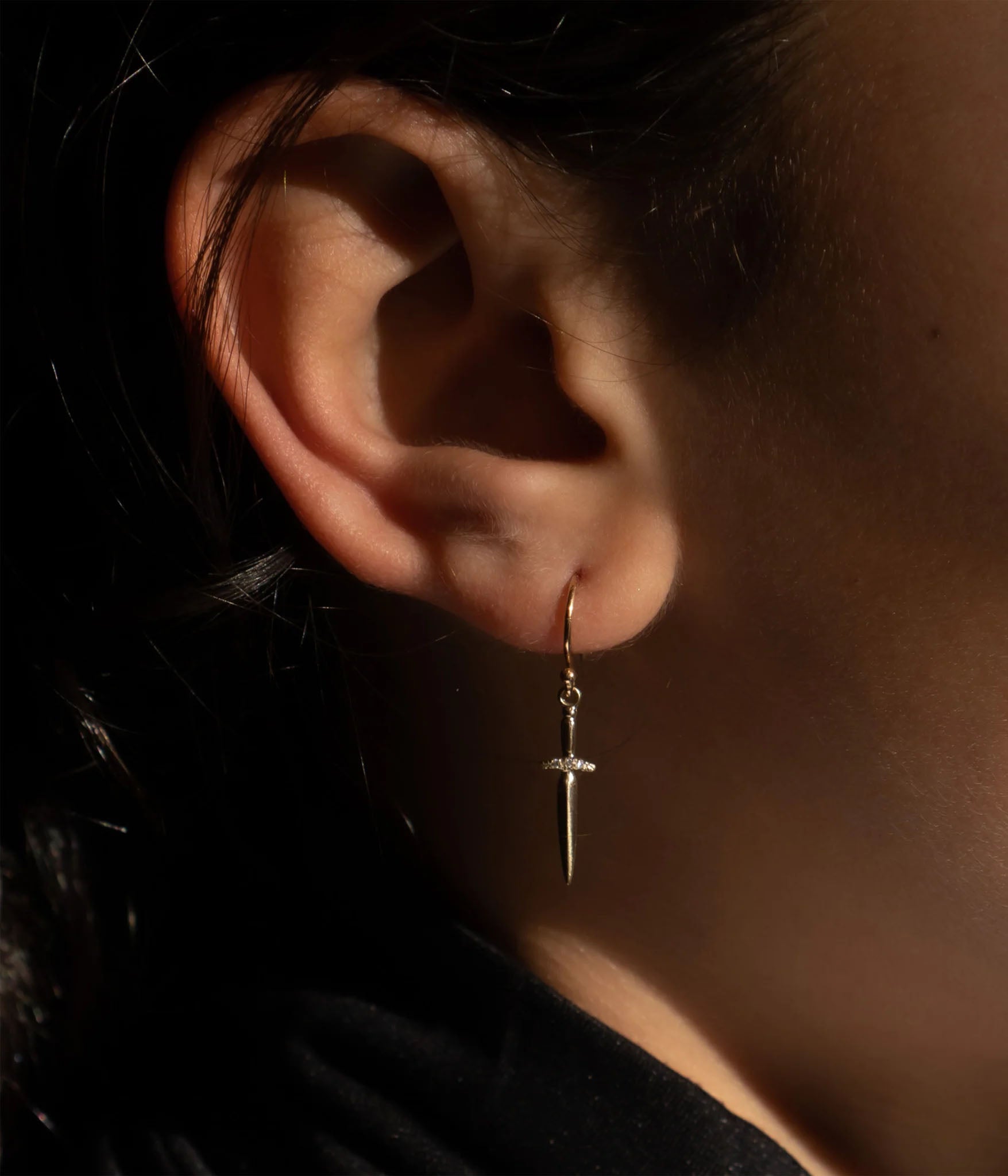 Dagger hoop earring in 14k yellow gold with 3 diamond accent on model 