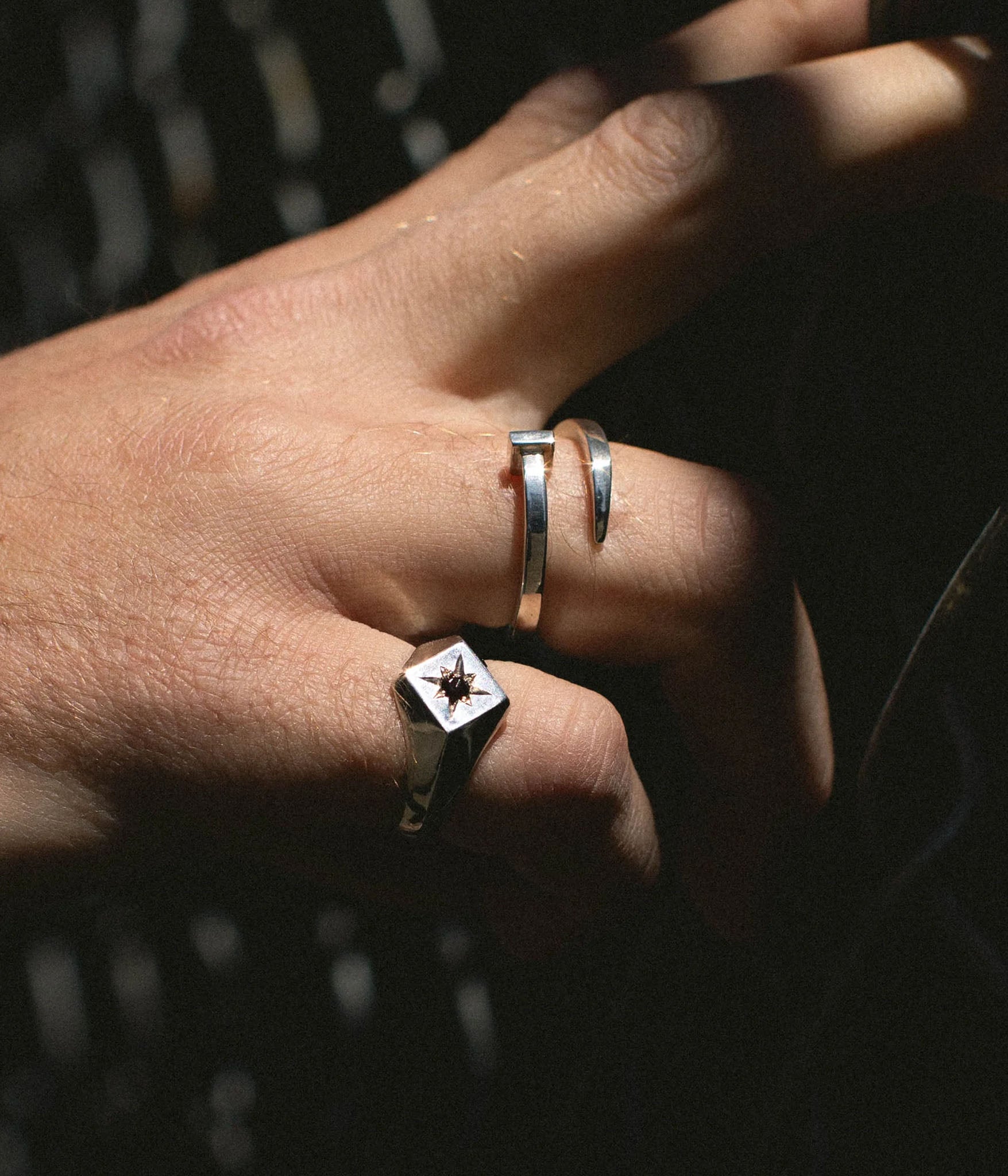Square north star signet ring with black diamond on pinky finger 