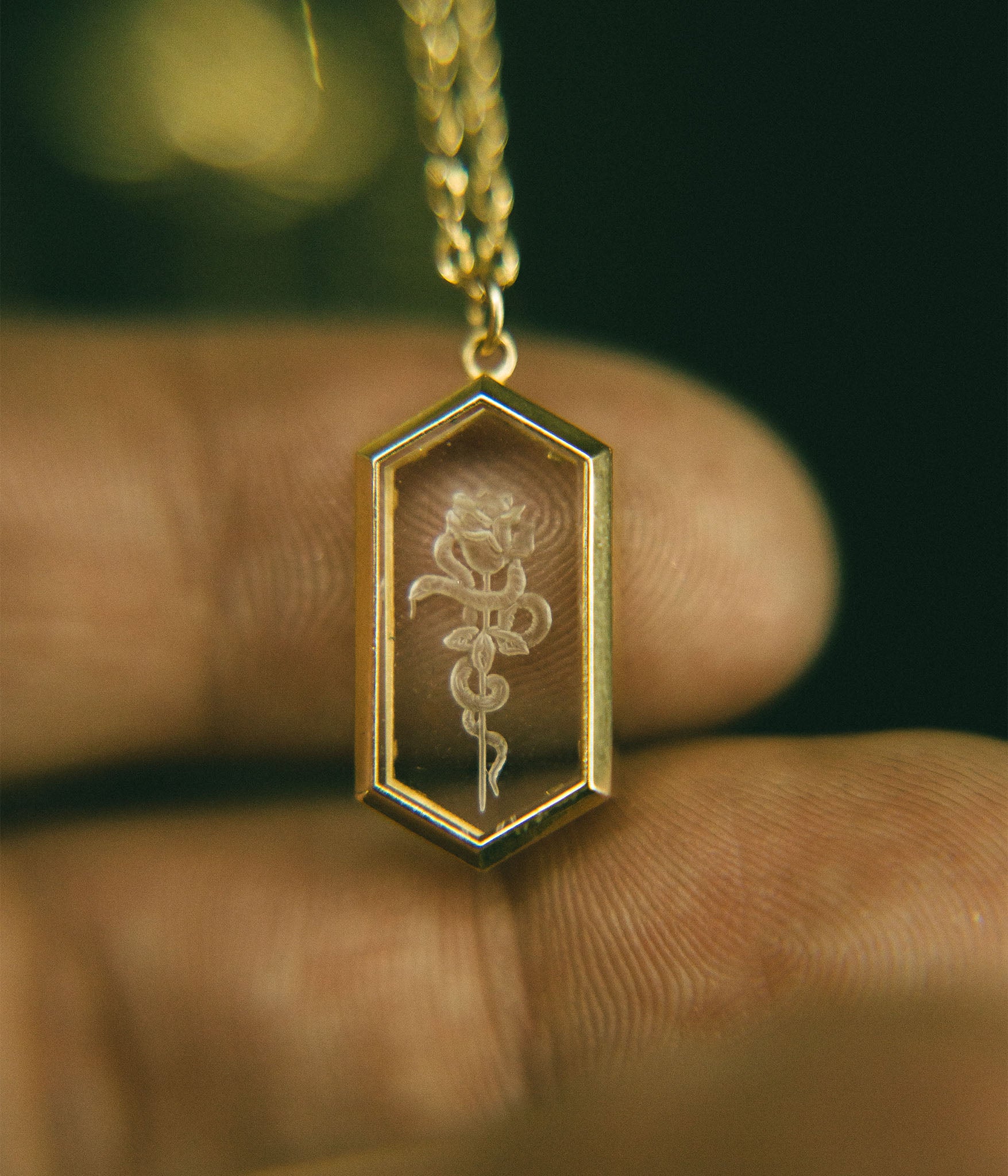 Hexagonal intaglio pendant featuring clear quartz with intricate hand-carved designs. 