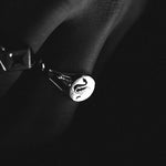 Traditional round sterling silver signet ring with snake engraving by Futaba for The Hunt in harsh light in black and white on models hand