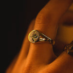 Traditional round sterling silver signet ring with snake engraving by Futaba for The Hunt close up shot on models hand
