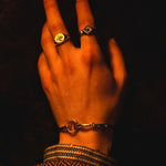 Traditional round sterling silver signet ring with snake engraving by Futaba for The Hunt on male models hand in yellow light