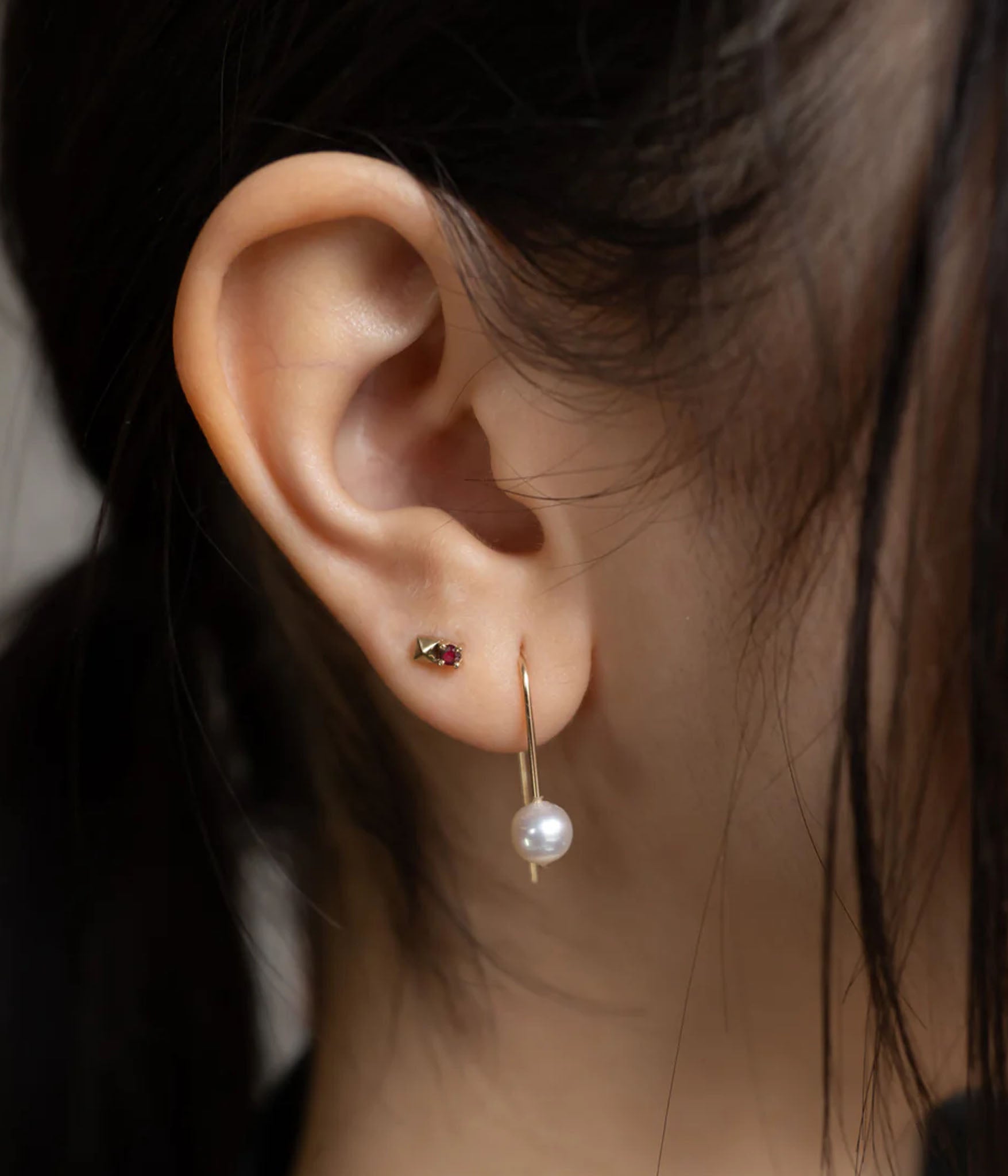 gold and ruby spike stud earring on ear