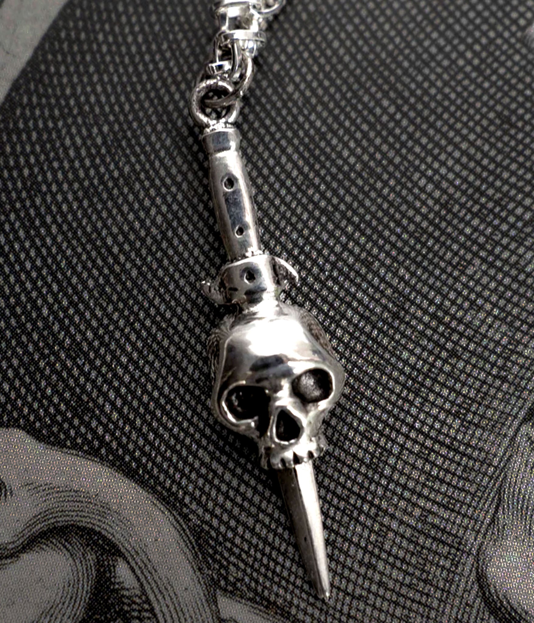 close up shot of skull and switchblade pendant necklace in sterling silver 